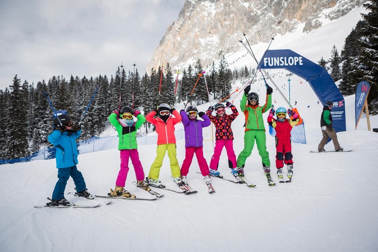 Viele Kinder stehen auf Skiern in einer Reihe