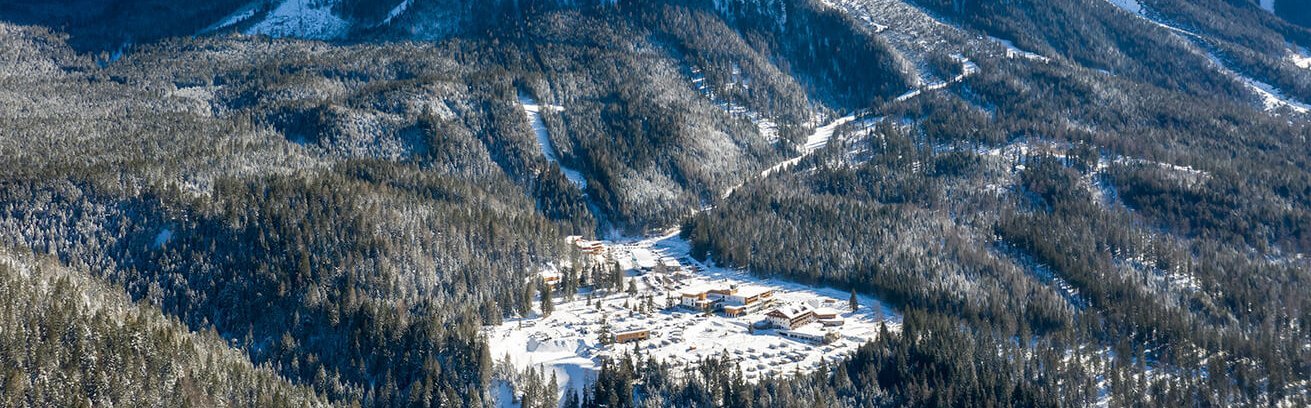 Einzigartige Panoramalage am Fuße der Zugspitze in Ehrwald Luftaufnahme des Resorts mit Blick auf die Zugspitze im Winter