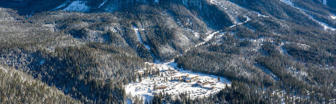 Einzigartige Panoramalage am Fuße der Zugspitze in Ehrwald Luftaufnahme des Resorts mit Blick auf die Zugspitze im Winter