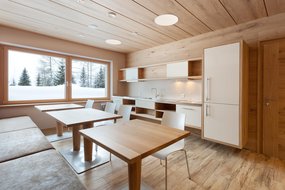 Tische und Stühle und eine Küche im Badehaus im Zugspitz Resort