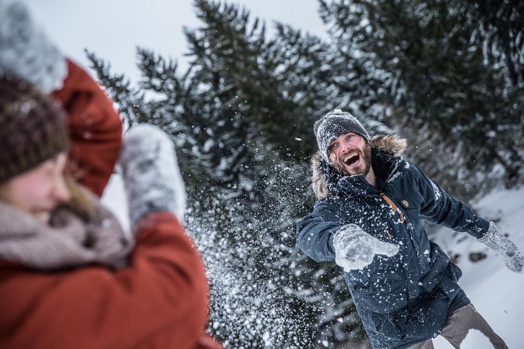 Winterspaß in Ehrwald Paar bei der Schneeballschlacht