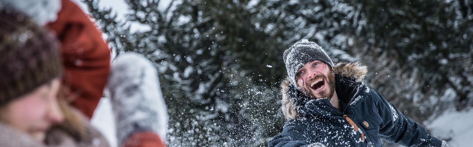 Winterspaß in Ehrwald Paar bei der Schneeballschlacht