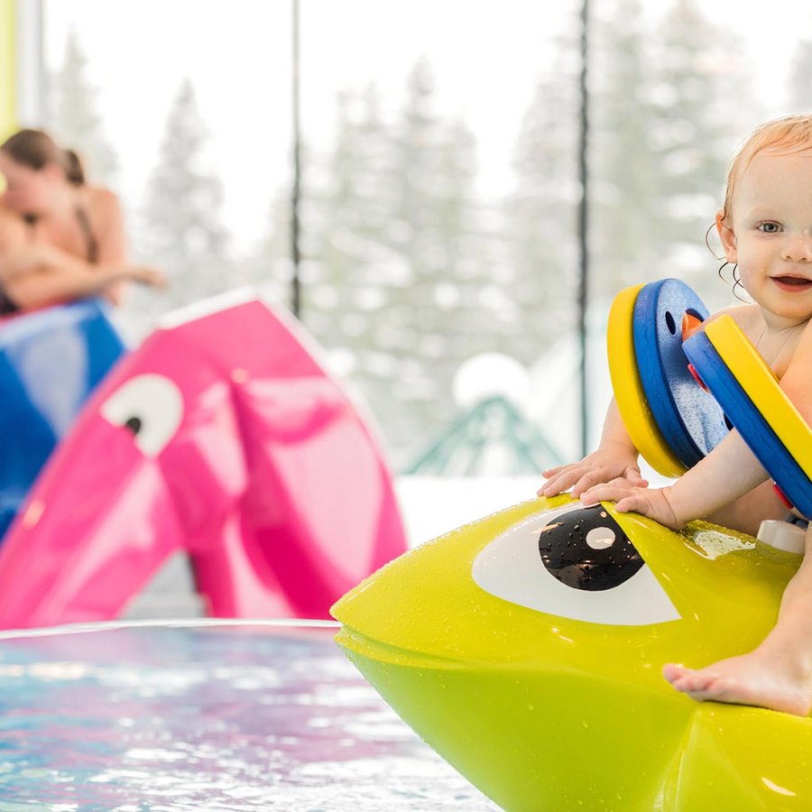 Kleinkind sitzt auf einer Sitzgelegenheit im Kinderpool