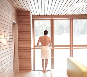 Mann steht im Badehaus im Zugspitz Resort
