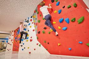 Kinder klettern auf der Boulderwand