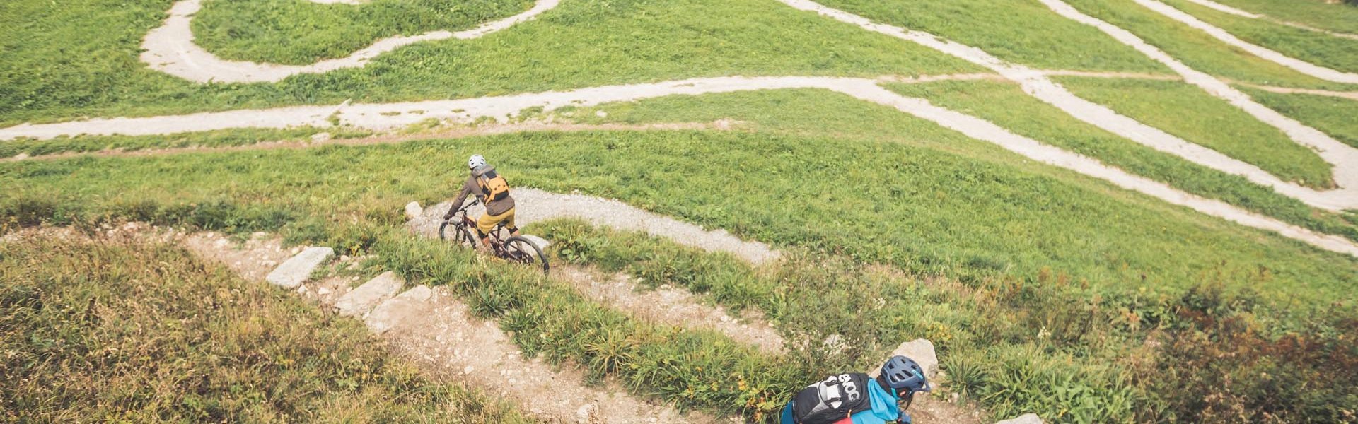 Zwei Mountainbiker fahren einen Mountainbike-Trail hinunter