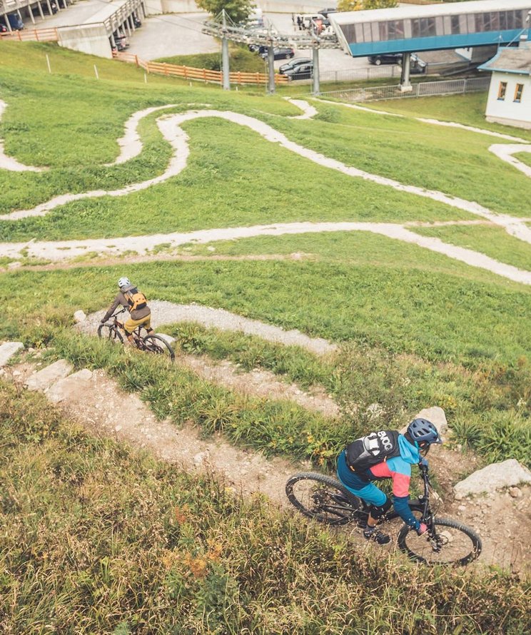 Zwei Mountainbiker fahren einen Mountainbike-Trail hinunter