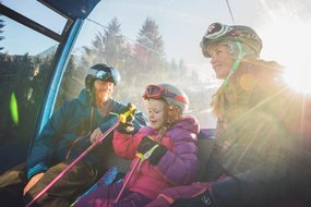 Familie in der Gondel im Skigebiet