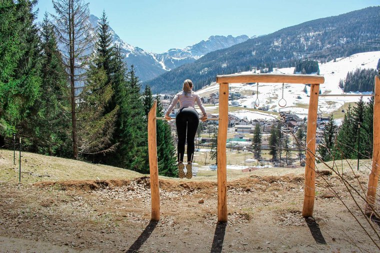 Frau macht Sportübungen im Freien auf einem Sportgerät