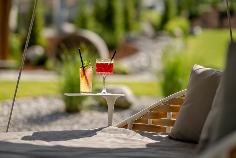 Zwei Cocktails auf einem kleinen Tisch im Garten