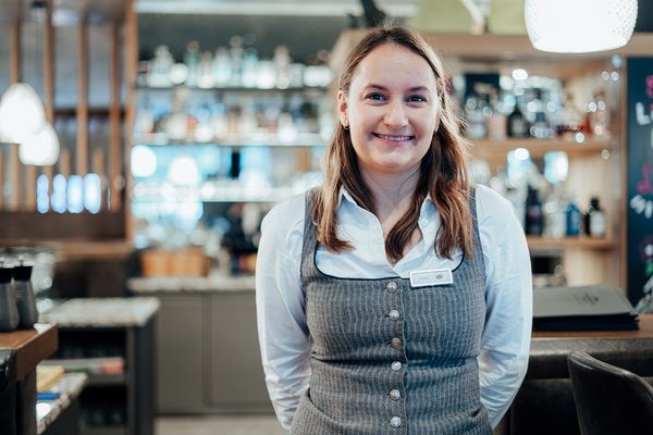 Mitarbeiterin von der Bar die freundlich in die Kamera lächelt