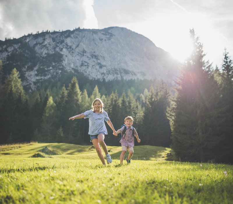 Kids am Wassererlebnisweg Zwei Kinder laufen durch das grüne Gras