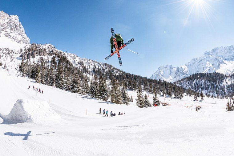 Skifahrer springt über eine Schanze im Snowpark