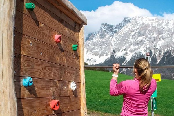 Frau macht Klimmzüge am Klettergerüst