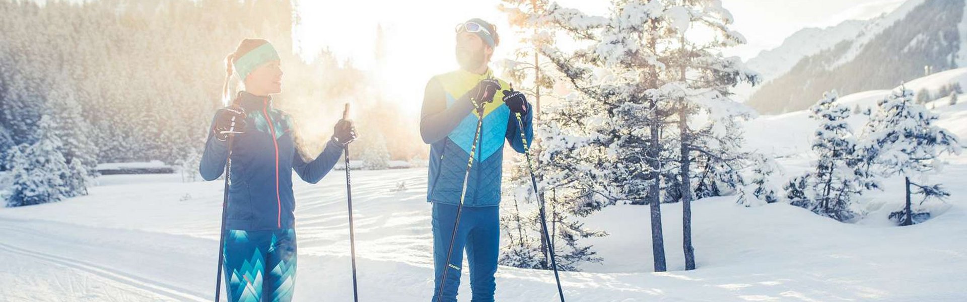 Zwei Langläufer stehen auf der Loipe in der Winterlandschaft