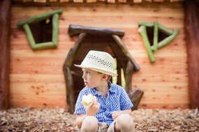 Kind vor dem Kinderspielhaus