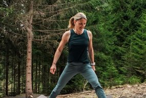 Frau macht Sportübungen im Wald auf einem Sportgerät