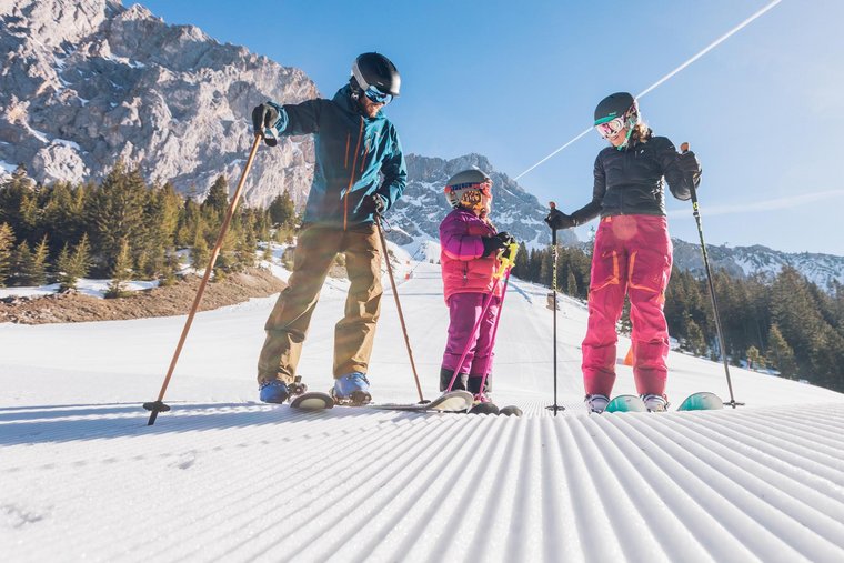 Familie beim Skifahren auf der Piste