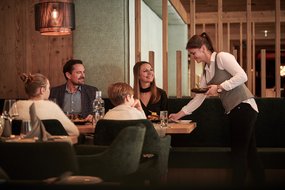 Erstklassiger Service im Resort Servicekraft serviert etwas zum Esstisch