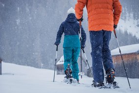 Schneeschuhwandern im Winterwonderland Paar von hinten beim Schneeschuhwandern