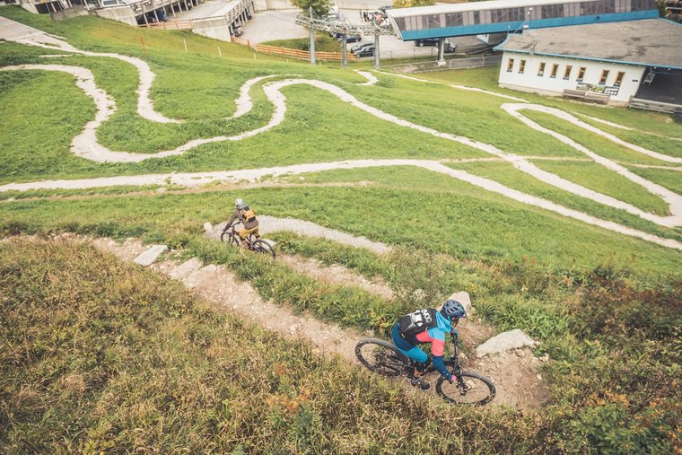 Mountainbike-Trail Zwei Mountainbiker fahren einen Mountainbike-Trail hinunter