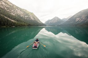 Paar auf Bootsausflug auf Gebirgssee