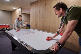 Vater und Sohn spielen Airhockey